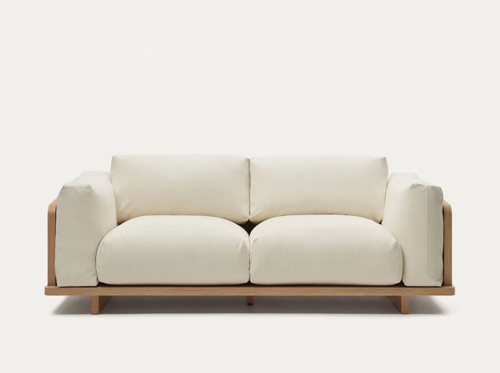 Sofa mit beigen Kissen und Holzbeinen